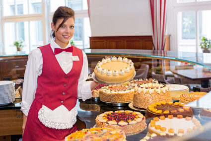 Frau steht an einem großen Kuchenbuffet in Lübeck